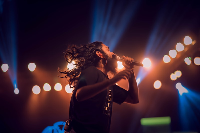 Singer on stage in teal and amber stage lighting