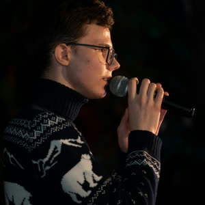 Teenage boy singing into a microphone during a singing lesson
