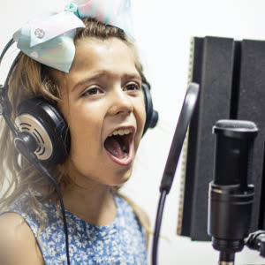 Young girl recording vocals with headphones