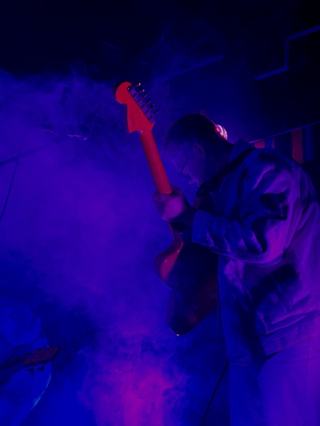 Louie performing live under purple stage lights